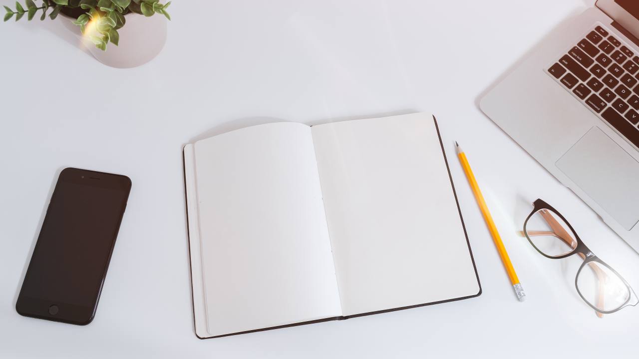 Laptop, notes and phone on a white work table